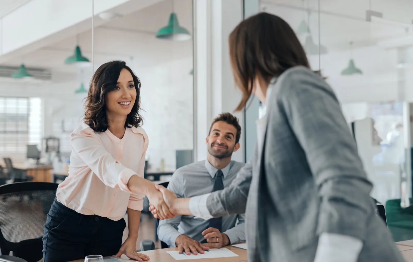 Business professionals shaking hands in modern office